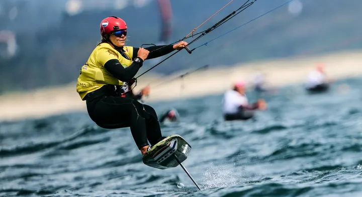 Jessie Kampman in the yellow leader's bib, low and hooked into the bar, the foil throwing a thin line of spray behind her at Viana do Castelo.